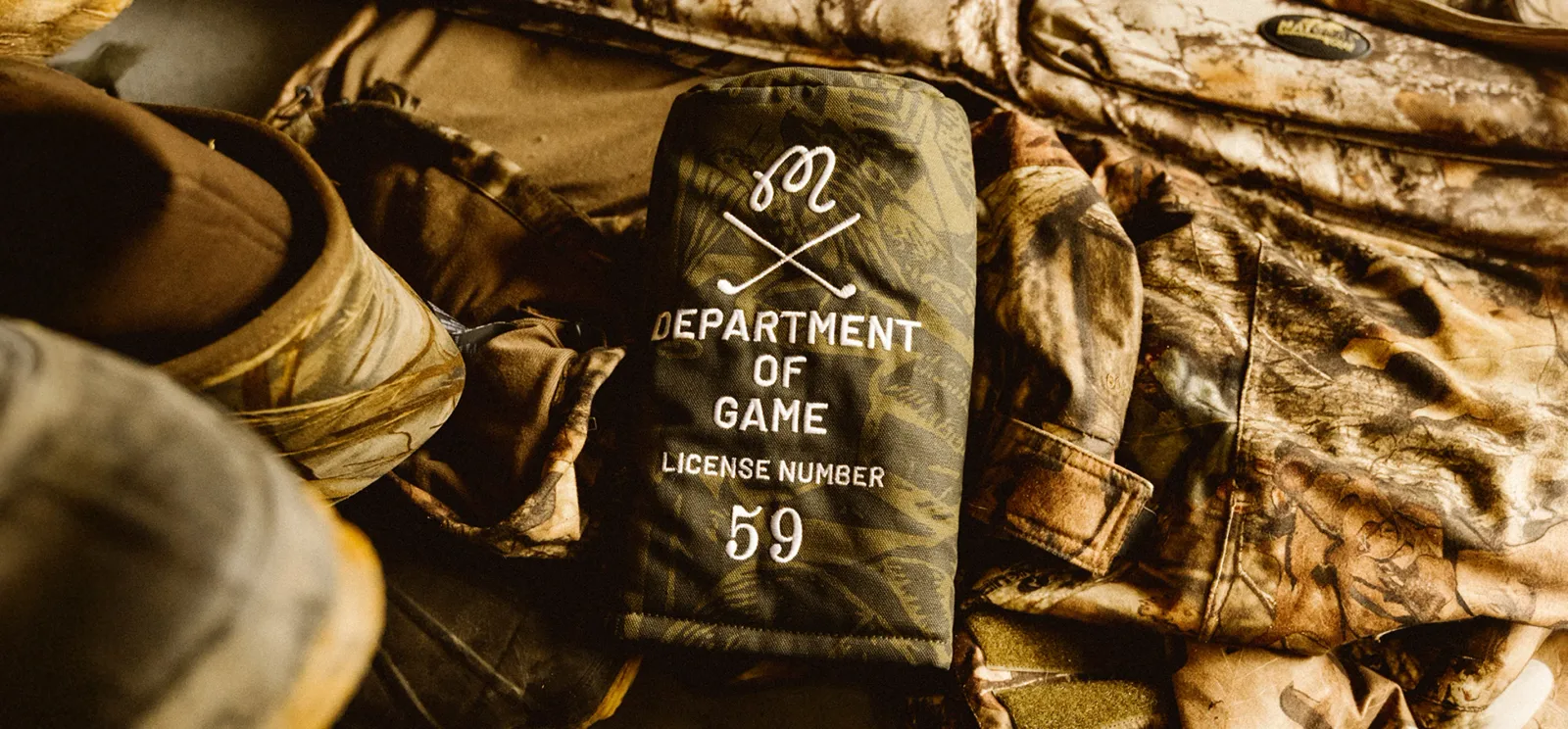 Close-up of a canvas patch reading Department of Game, Licence Number 59, on olive camouflage fabric